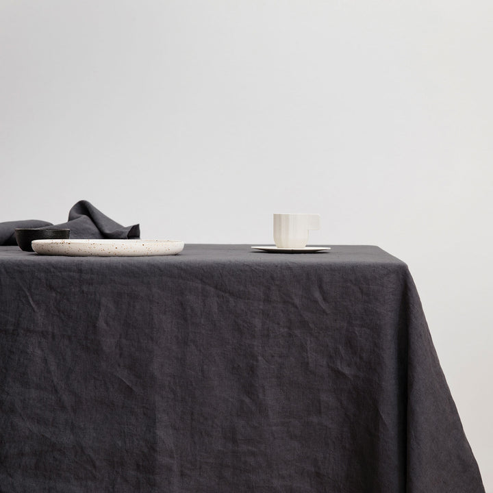 The Linen Tablecloth in Slate styled with various ceramic objects.