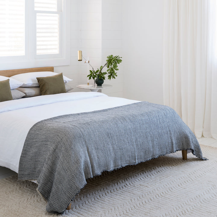 A bed dressed in a Linen Duvet Cover with a Mira Ellis throw. Sizes: Queen, King