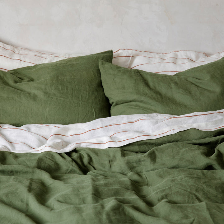 A close up of a bed dressed in Forest and Cedar Stripe bed linen. Sizes: Queen, King