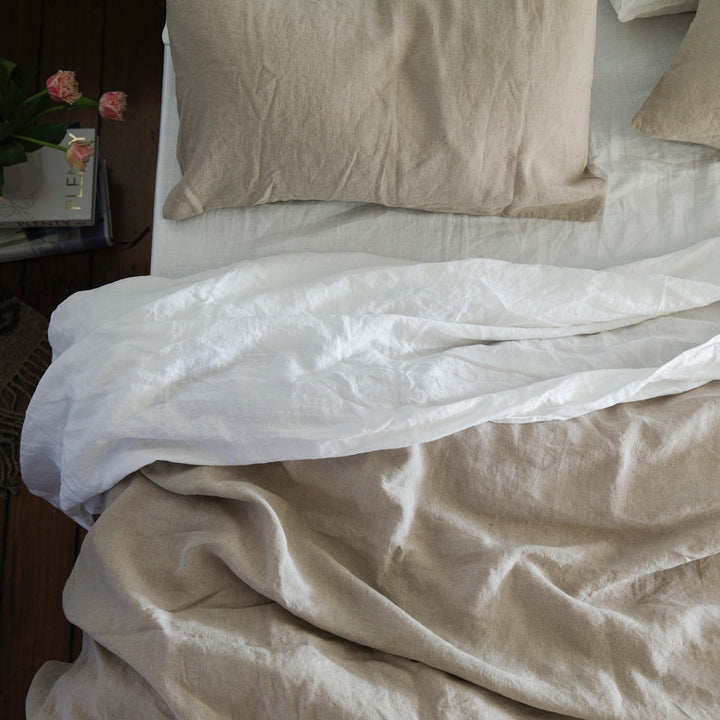 A bed dressed in Natural and White bedlinen.