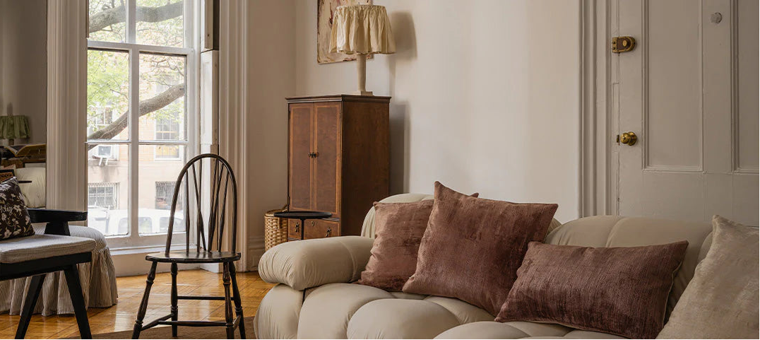 Living room with a beige sofa, brown cushions, and a wooden cabinet.