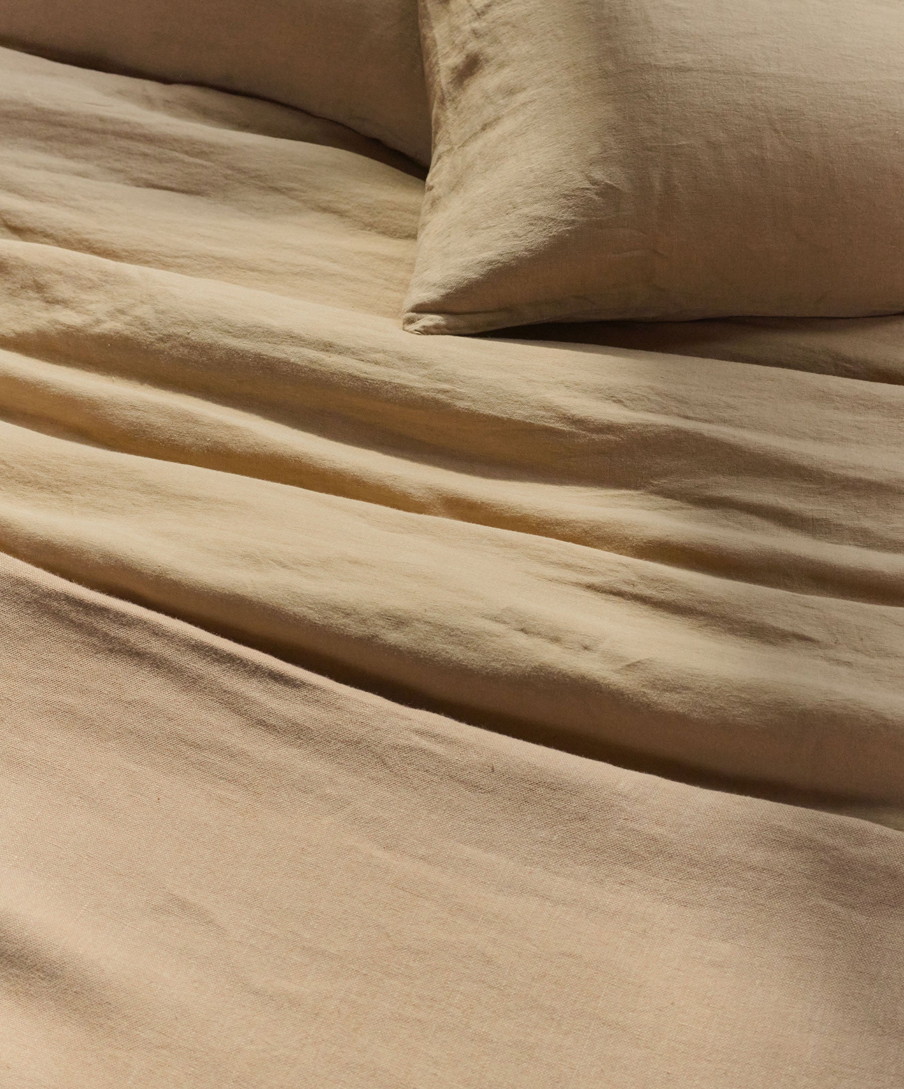 Beige bedding set with a pillow on a bed
