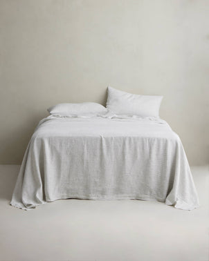 Pinstripe linen sheet set with pillowcases by CULTIVER styled on a bed for a stylish, comfortable bedroom look.