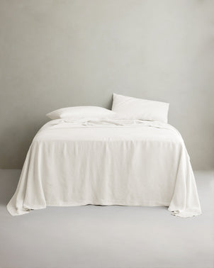 Ivory linen sheet set with pillowcases from CULTIVER displayed on a bed, showcasing soft, breathable bed linen for a cozy sleep.