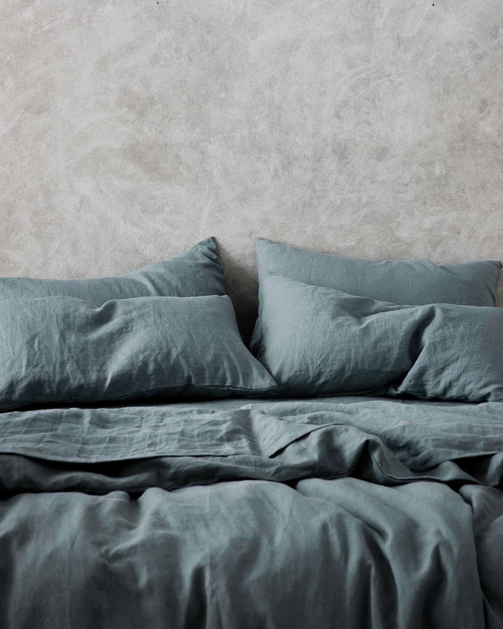 Cream-colored linen flat sheet from CULTIVER's Bluestone bed linen collection, shown flat on a bed.