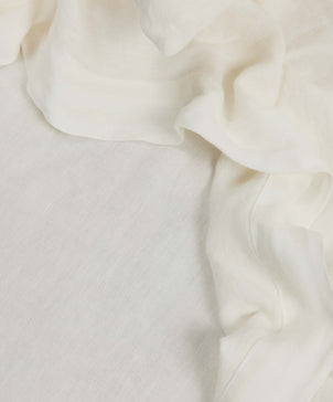 A close-up of the Complimentary Swatch - Ivory shows soft, off-white linen fabric with gentle folds and textured drape, making it perfect for selecting the ideal material for your home.