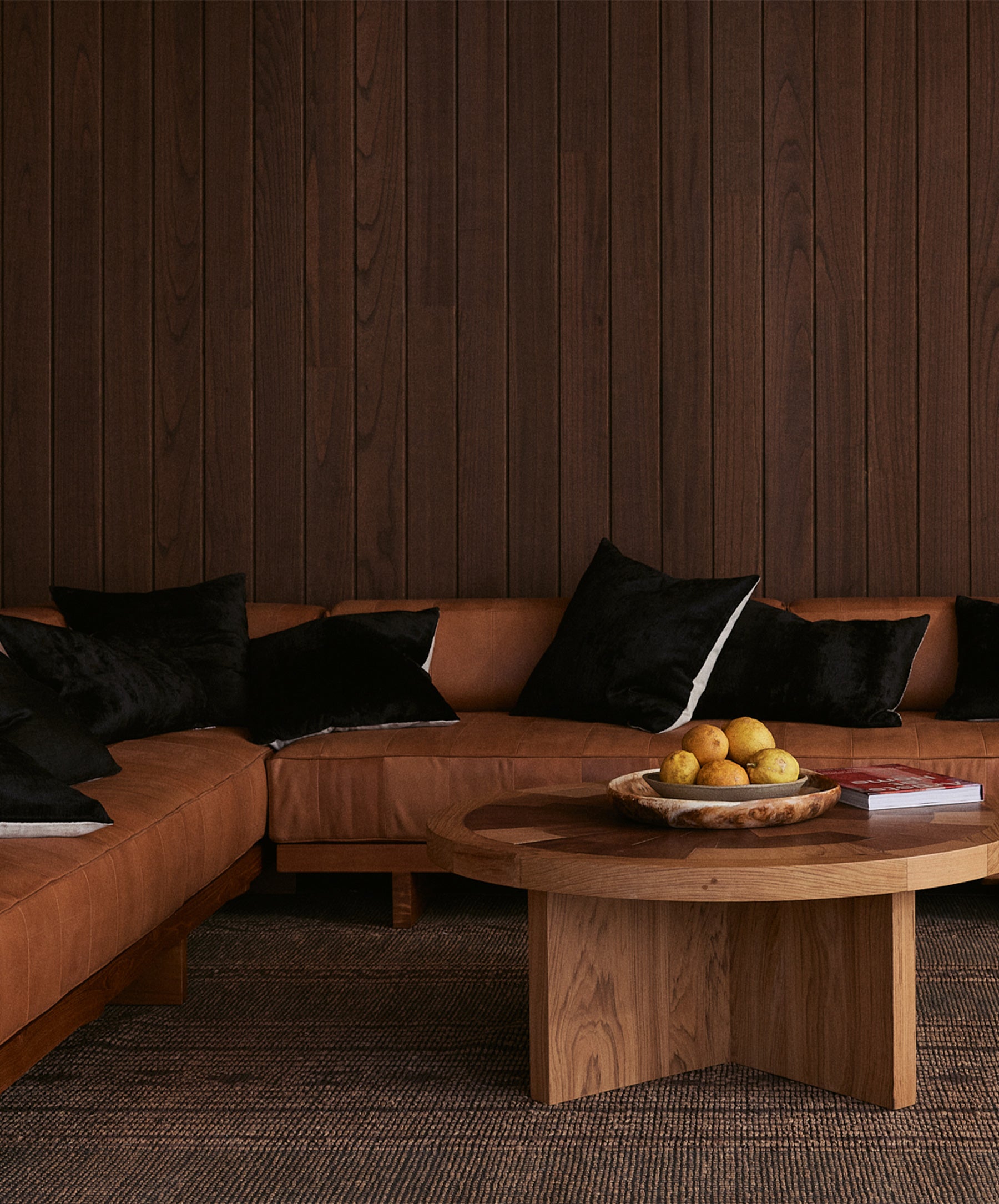 Close-up of a textured brown blanket and pillows on a bed.