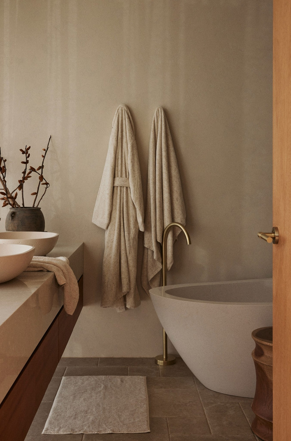 Bathroom with a freestanding bathtub, towel, and decorative elements.