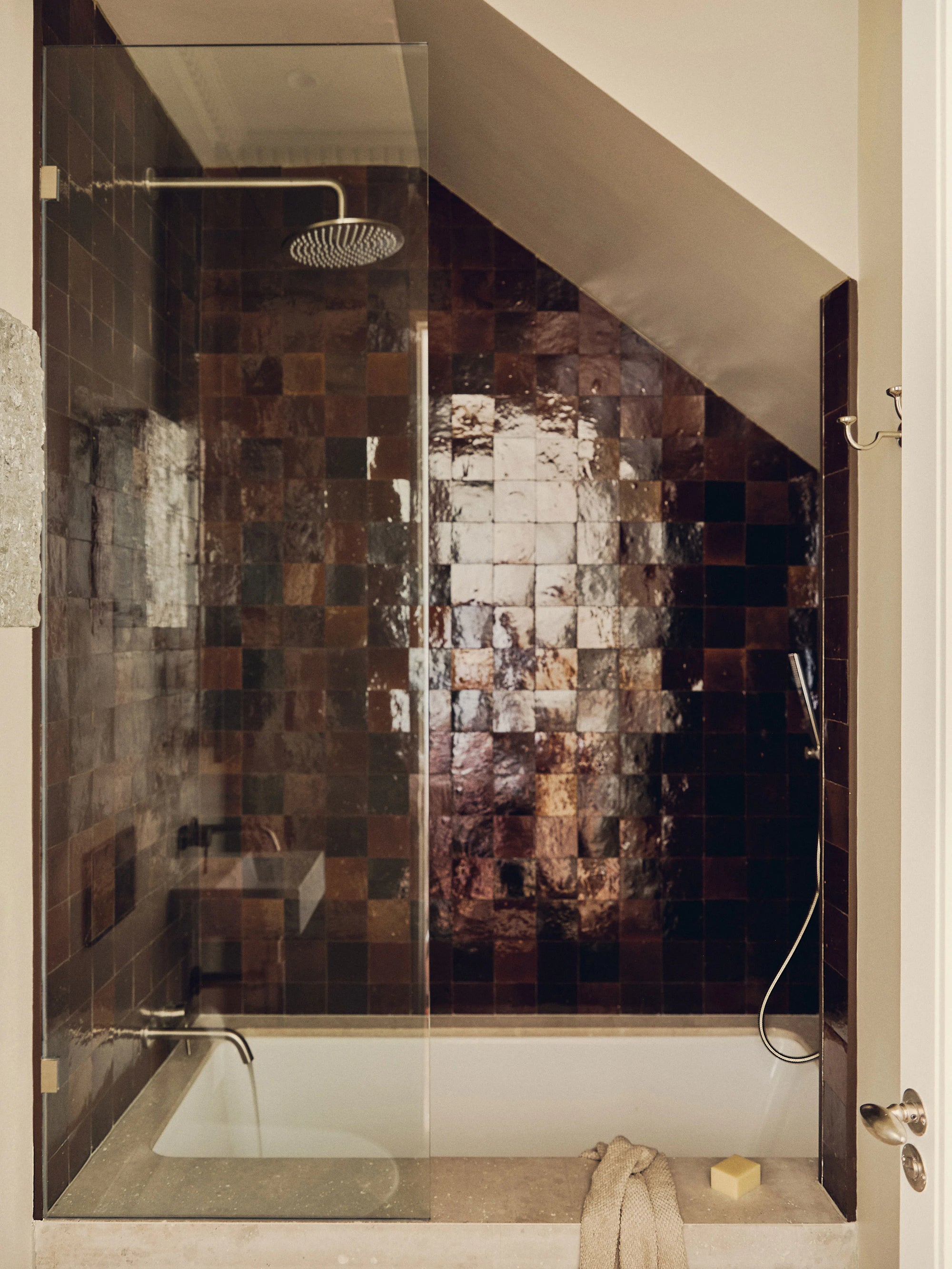 Modern shower with glass enclosure and mosaic tile wall