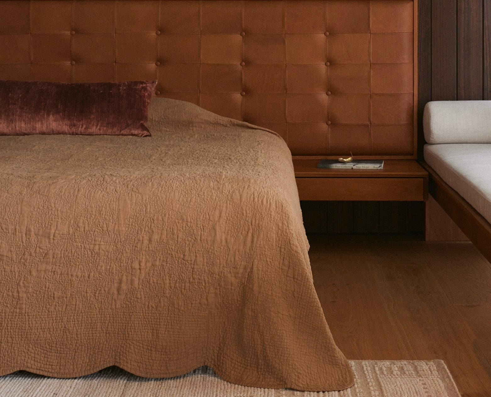 Bed with brown bedding and headboard in a bedroom setting