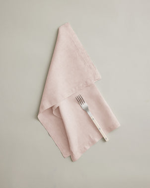 Soft blush linen table napkin from CULTIVER, featuring a smooth texture and elegant fold, perfect for sophisticated table settings.