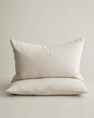 Two natural linen pillowcases from CULTIVER, styled and stacked, showcasing soft, breathable bed linen for a cozy bedroom.
