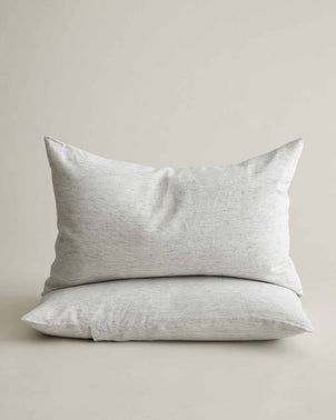 Set of two CULTIVER linen pillowcases in pinstripe design, stacked, showcasing soft, breathable bed linen for a stylish bedroom.