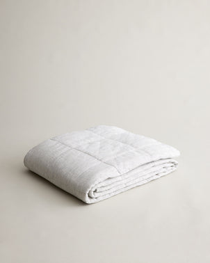 Cultiver quilted bedcover in pinstripe pattern, neatly folded, showcasing soft fabric and stylish design for cozy bedroom decor.