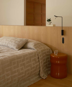 Bedroom with a bed, nightstand, and wall lamp.