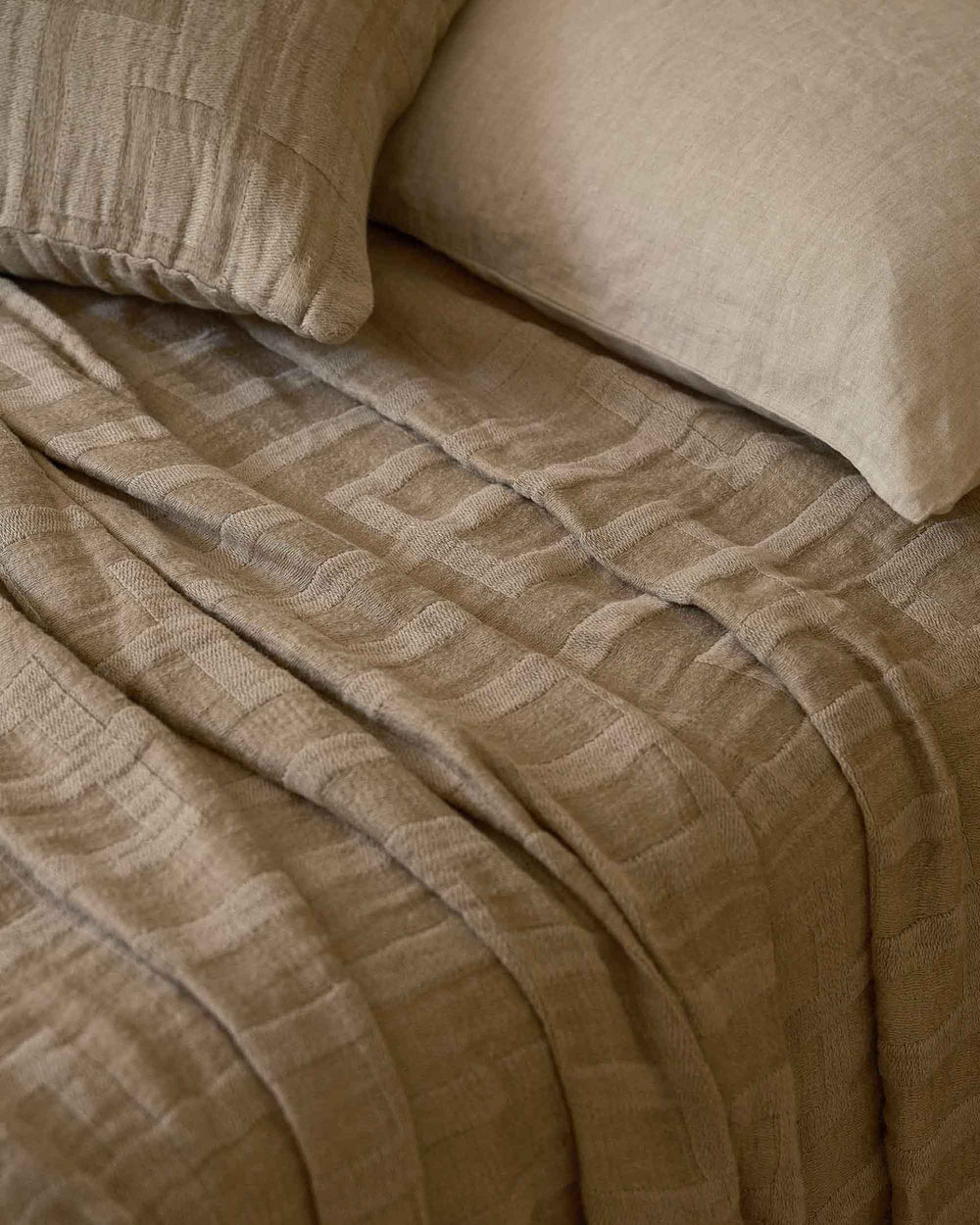 Close-up of CULTIVER Rolfes bedcover in natural color, showcasing its soft fabric and textured design for a cozy bedroom look.