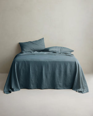 CULTIVER Bluestone linen sheet set with matching pillowcases styled on a bed, showcasing soft, breathable bed linen.