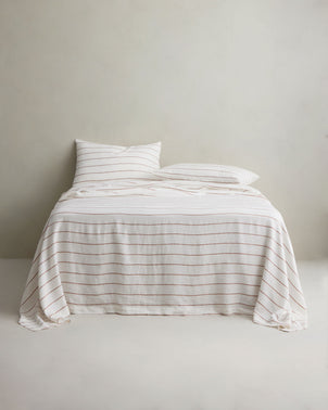 Linen flat sheet with cedar stripe pattern on a bed, showcasing soft, breathable CULTIVER bed linen for a stylish bedroom look.