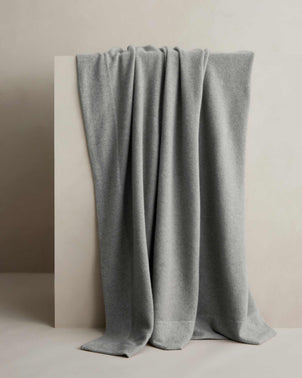 Cultiver Alba cashmere throw in fog color, showcasing soft, cozy fabric draped elegantly for a stylish home accessory.