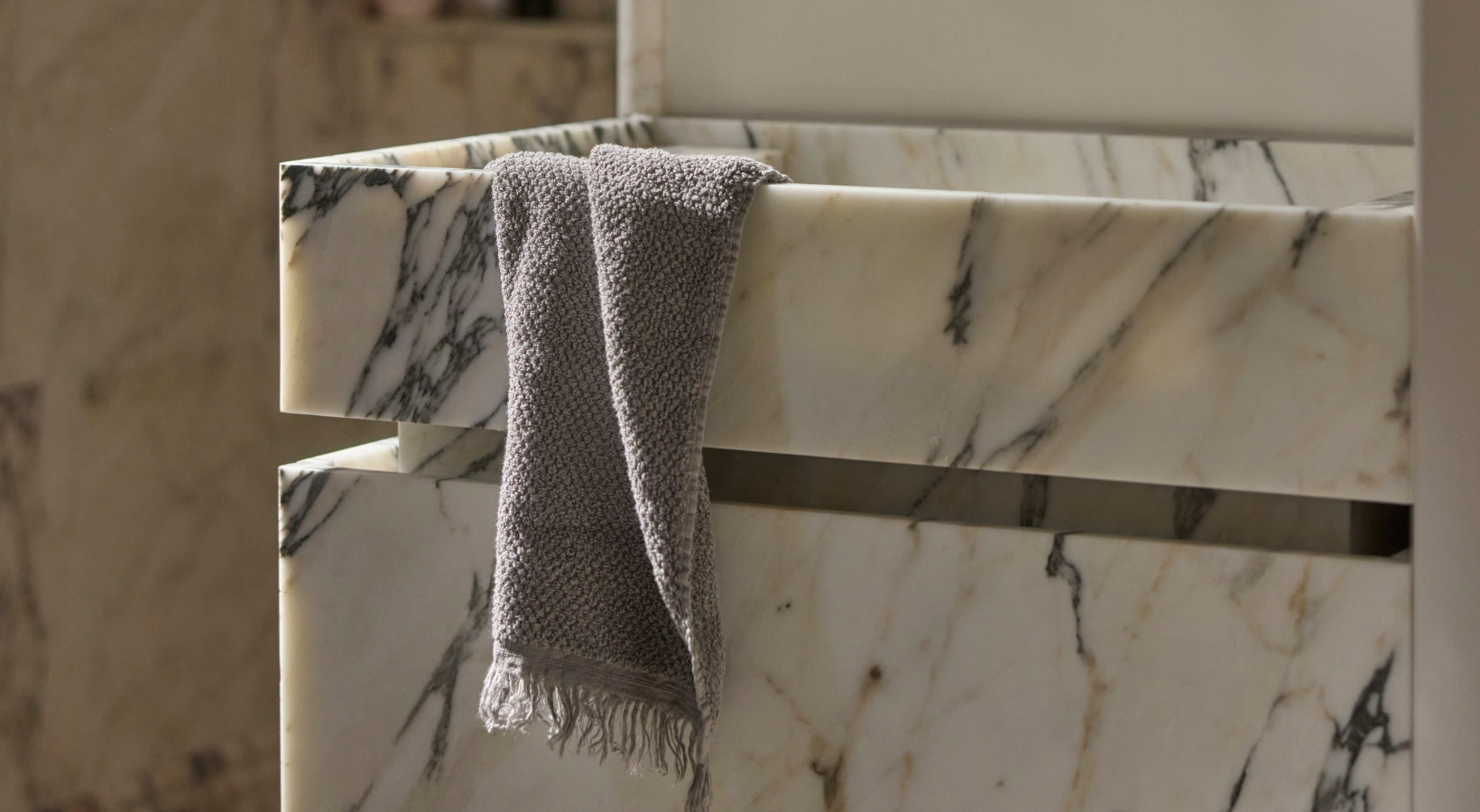 wash cloth hung over marble sink