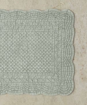 Textured green fabric square on a beige surface