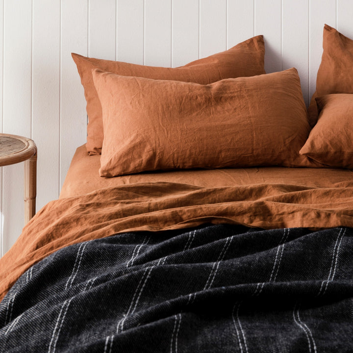 A bed dressed in Cedar bed linen, styled with a Mira Linen Bedcover in Rafa. Sizes: Queen, King