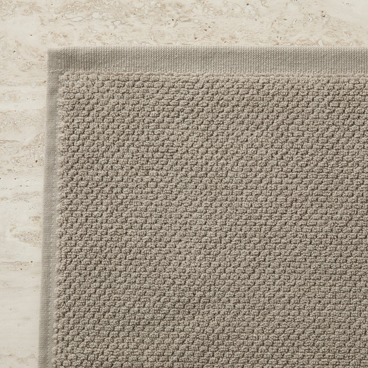 A close up of the corner of a Bath Mat in Natural