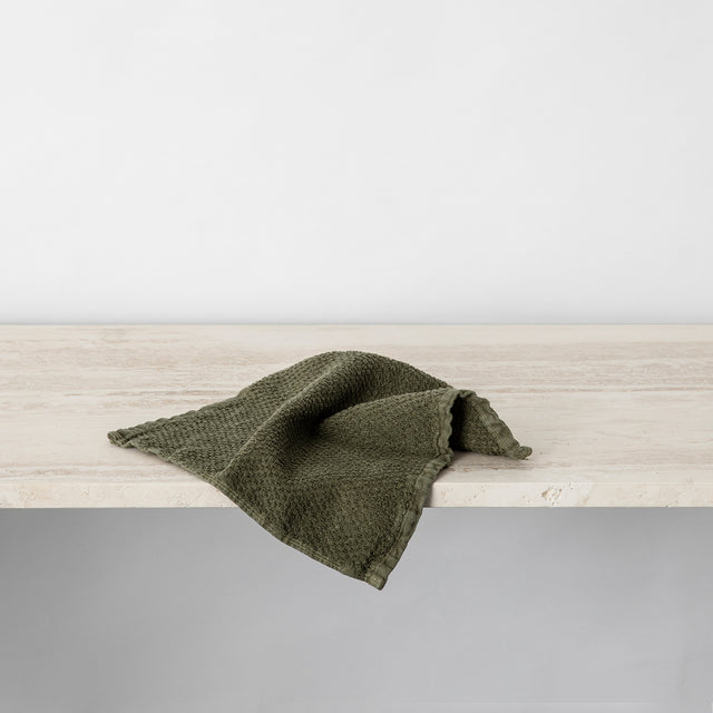Forest Pure Linen Wash Cloth hanging off ledge.