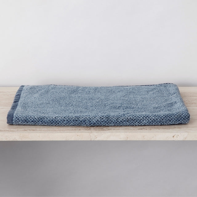 A folded denim bath mat