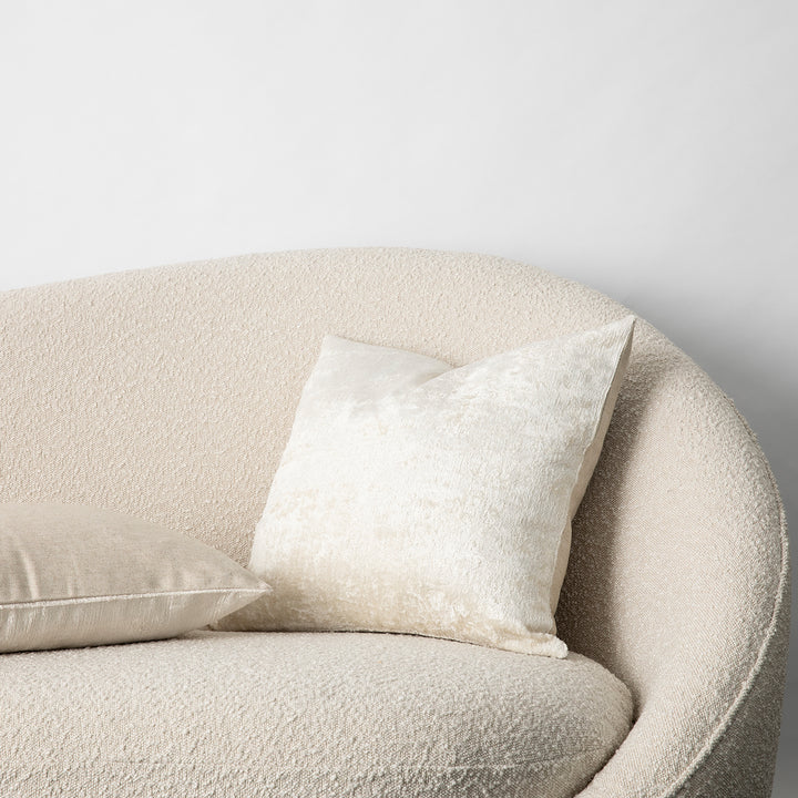 The Talik Velvet Cushion in Cream on a boucle lounge.