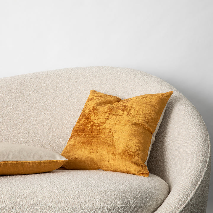 Talik Velvet Cushions in Mustard, on a boucle lounge.