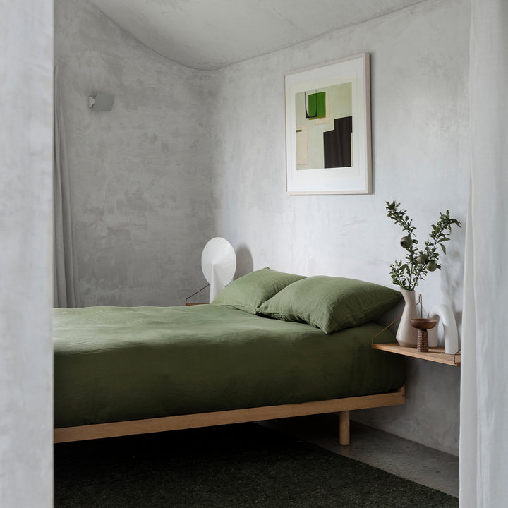 A bed dressed in Forest bed linen, styled with modern artwork and greenery. Sizes: Queen, King