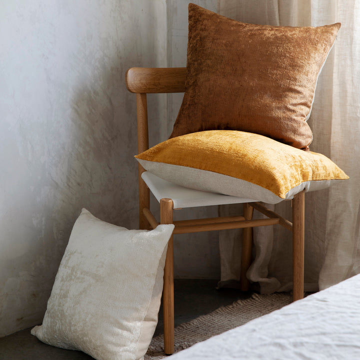 Talik Velvet Cushions in Fawn, Cream and Mustard styled with a wooden chair