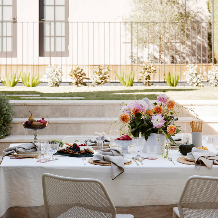 An outdoor dining setting featuring a Cara Panel Tablecloth