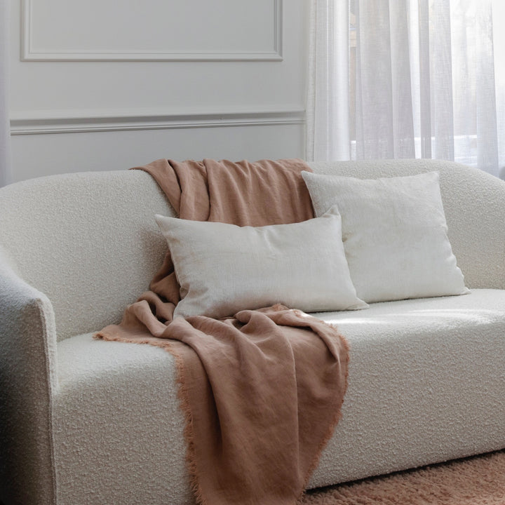 A cream sofa styled with a Freya Linen Throw in Fawn and Talik Velvet Cushions in Cream