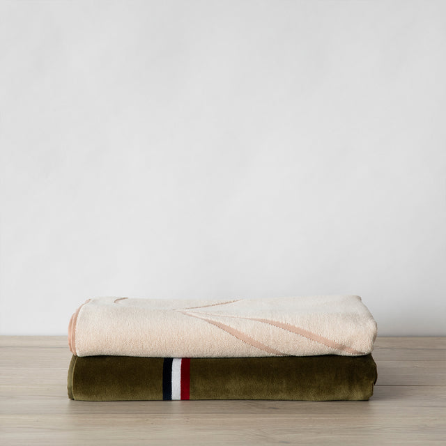 folded beach towels in rose and olive stacked