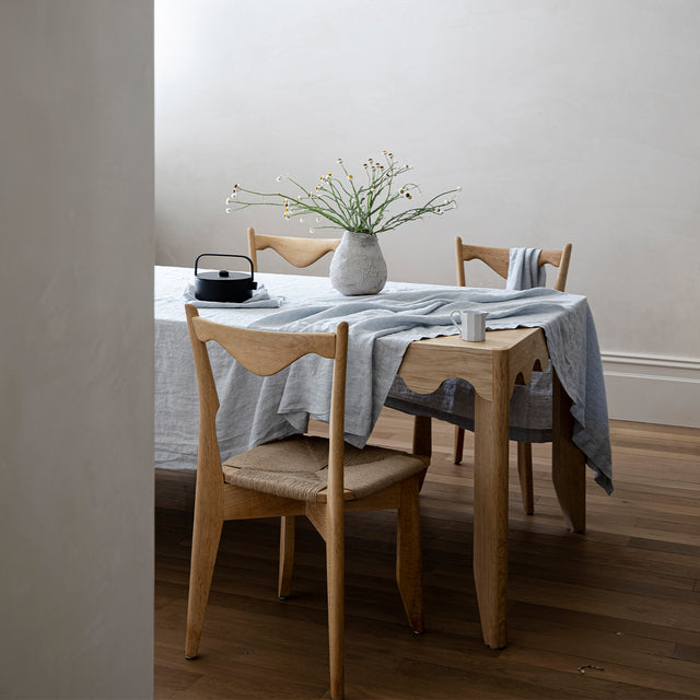 A wooden table styled with a Linen Tablecloth and Table Napkins in Sky