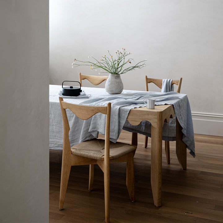 A wooden table styled with a Linen Tablecloth and Table Napkins in Sky