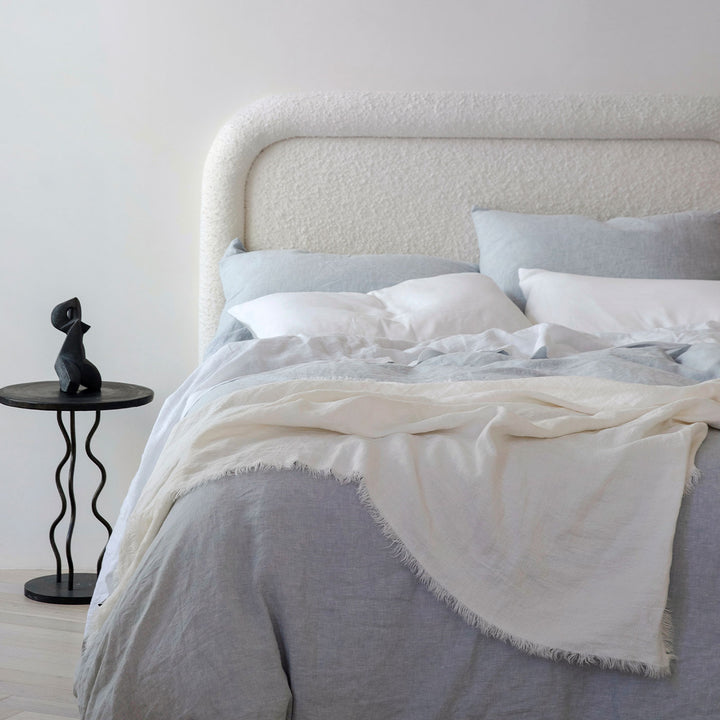 A bed dressed in Sky bed linen and the Freya Linen throw in Snow
