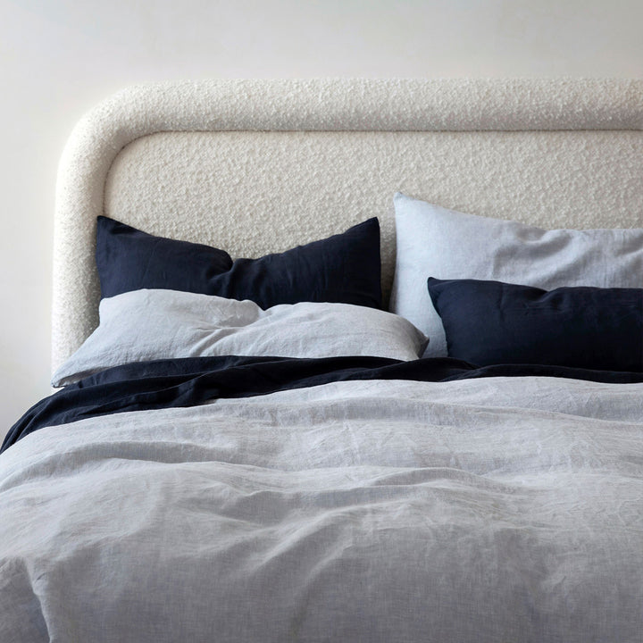 A cream bed dressed in Sky and Navy bed linen