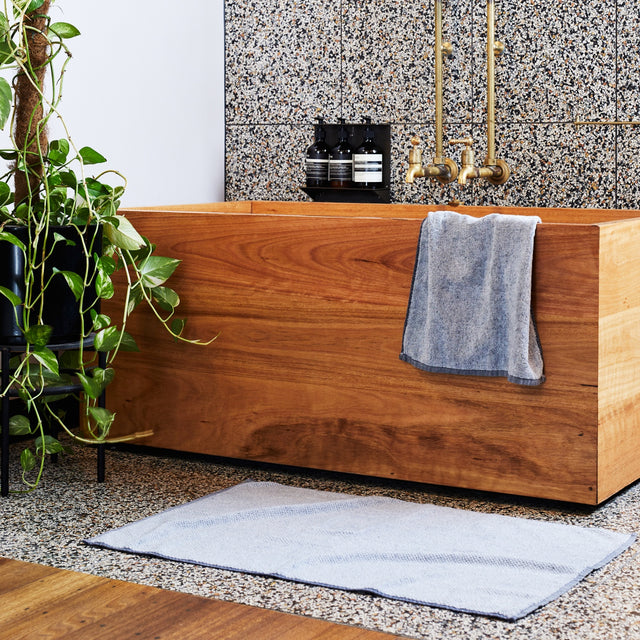  A modern bathroom featuring a denim bath towel and a denim bath mat