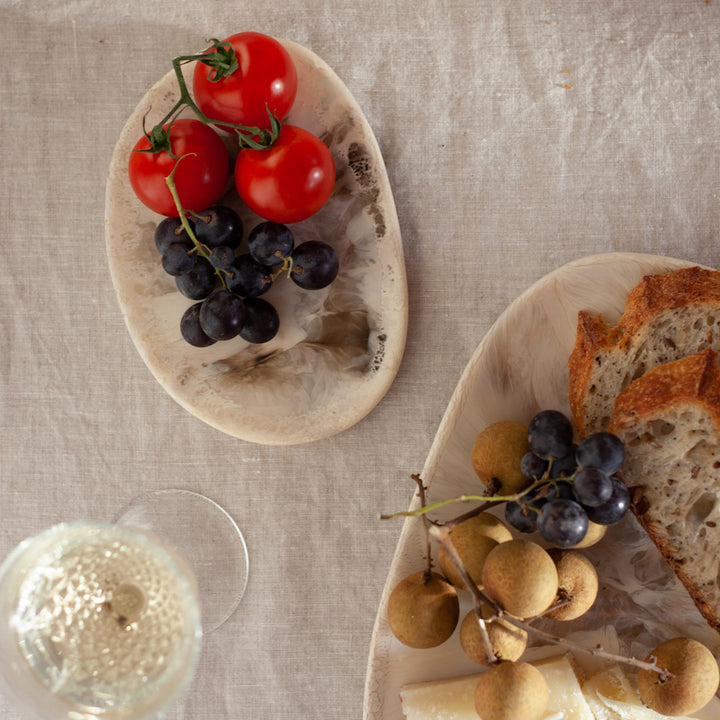 A close up of fresh fruit, pottery and a glass of wine on a Natural Tablecloth.