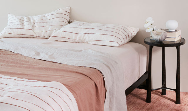 Bed styled with Cultiver linen bedding in Cedar Stripe and Fawn colors