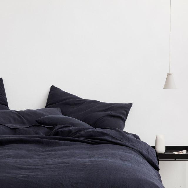 A bed dressed in Navy bed linen. Sizes: Queen, King