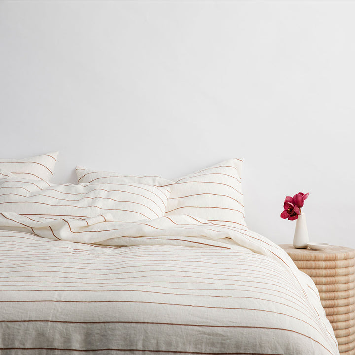 A bed dressed in Cedar Stripe bed linen. Sizes: Queen, King