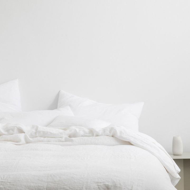 A bed dressed in White bedlinen