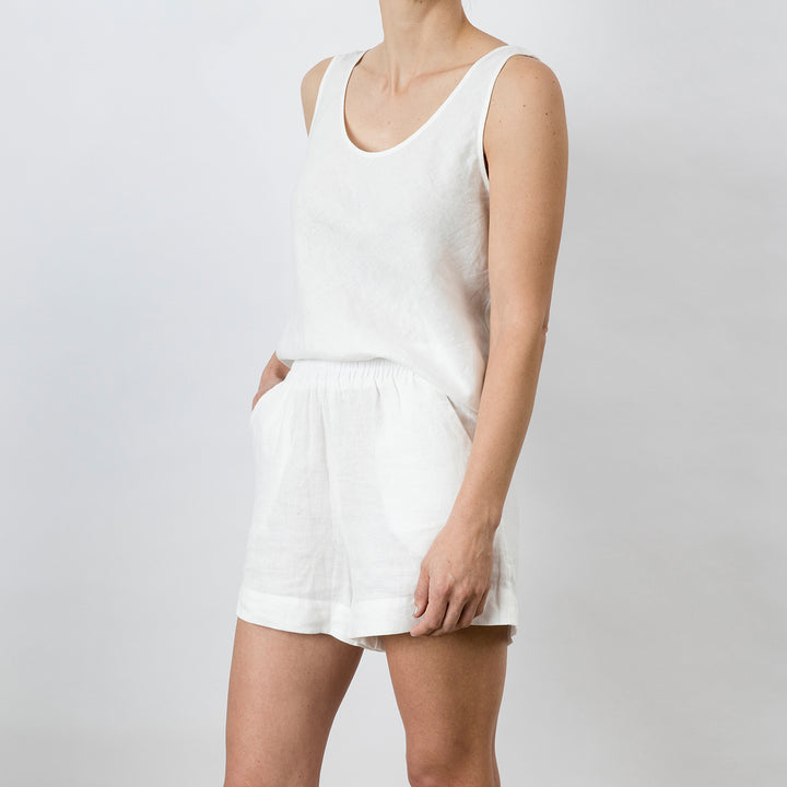 Side view of Piper Linen Short in White. Model is also wearing the matching Piper Linen Singlet in White.