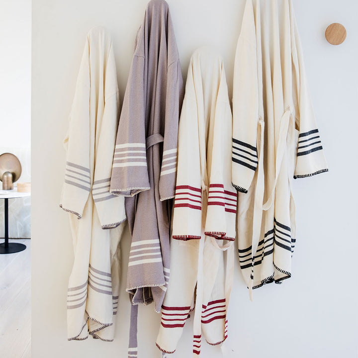 The Marais Robes hanging on a white wall.