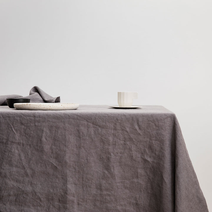 The Linen Tablecloth in Charcoal Gray styled with various ceramic objects.