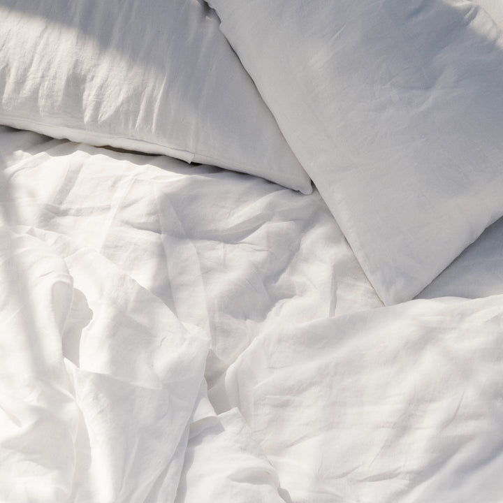 A bed dressed in White bed linen